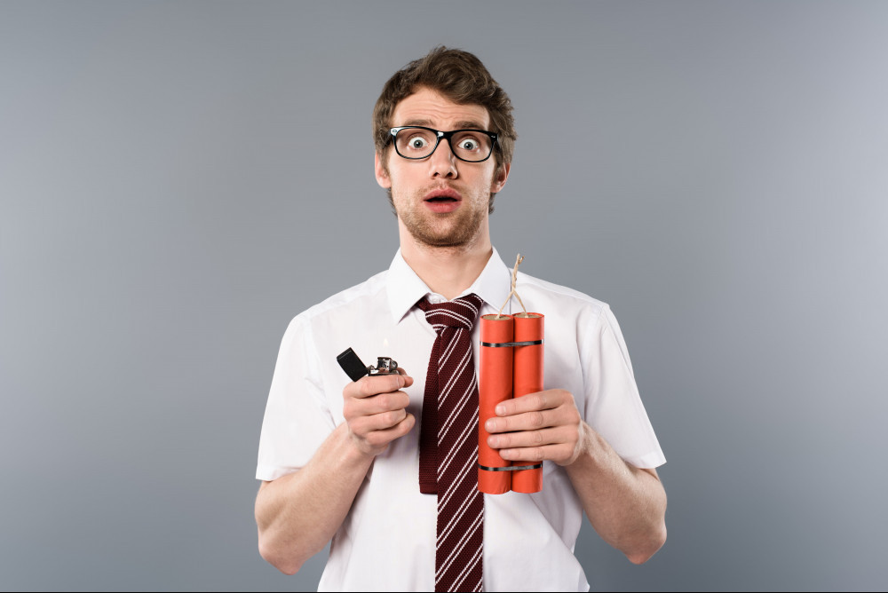 How To Optimize Google Ads: Photo Of Man Standing Looking Surprised Holding Explosives 